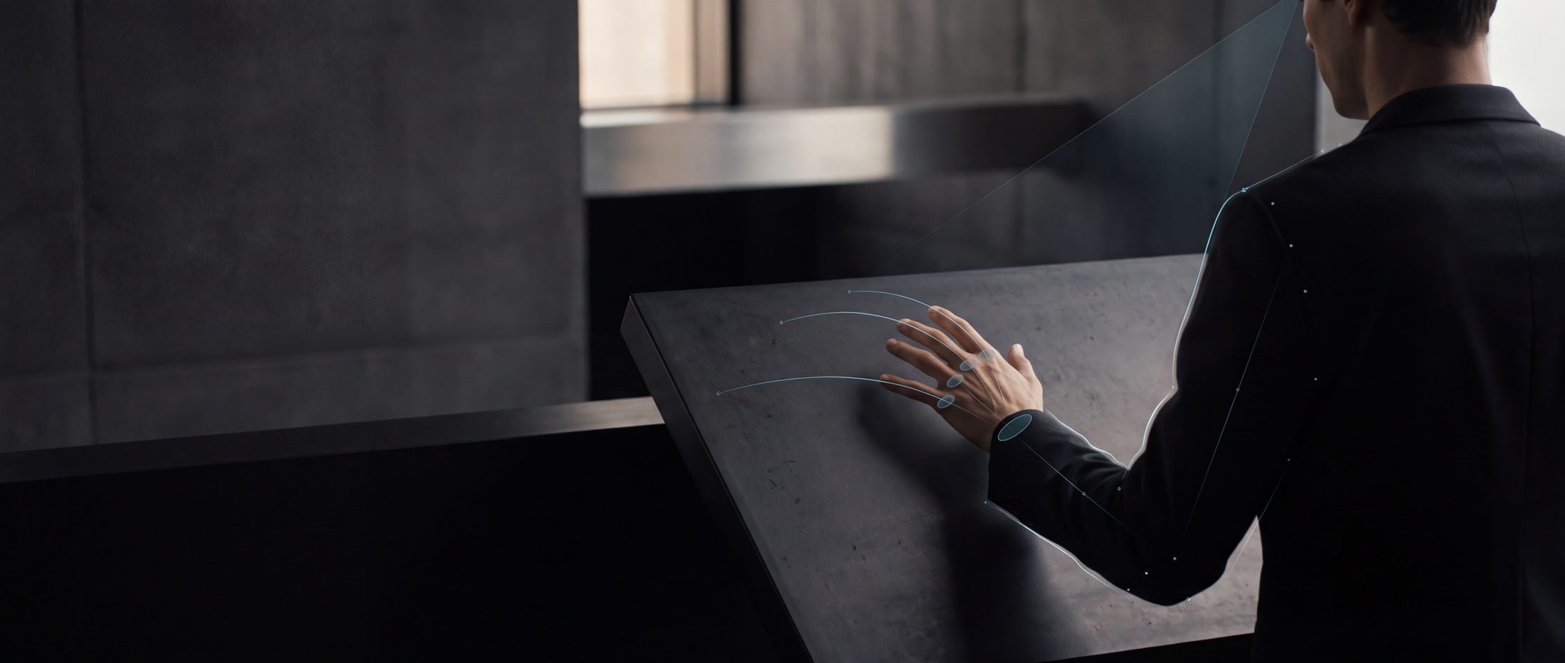 A person reaching toward a dark interactive surface with a faint predictive overlay